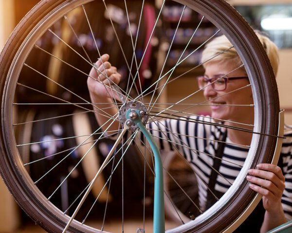 Eine Frau arbeitet an einem Fahrradreifen | © dusanpetkovic1 - fotostudiocolor24 - stock.adobe.com